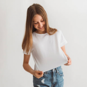 Jeune femme debout en t-shirt blanc, jeans
