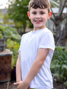 Garçon souriant en t-shirt blanc, fond nature