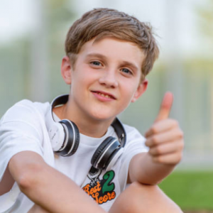 Garçon souriant avec un casque autour du cou